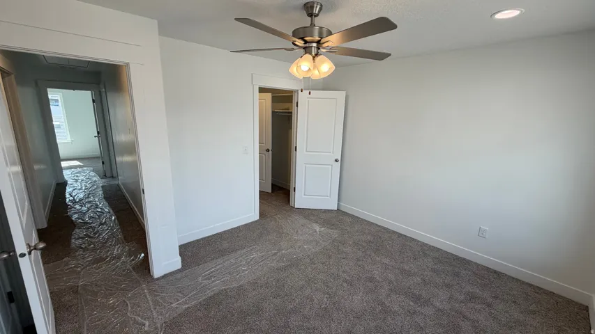 Recessed lighting, ceiling fan with integrated light fixture, neutral carpet flooring, white interior doors, and crisp white walls