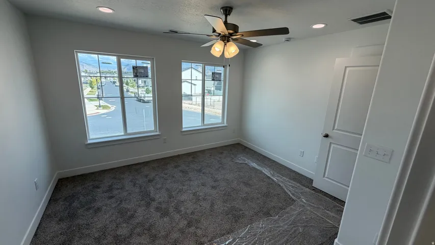 Carpeted room with recessed lighting and a ceiling fan