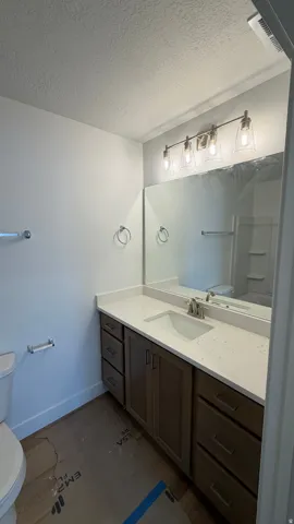 Single vanity with a light-toned countertop, undermount sink, and brushed nickel faucet