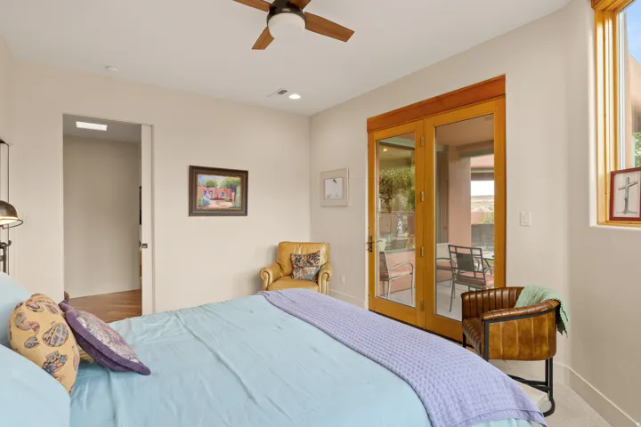 Wood-frame double French doors, wood-frame window, and a ceiling fan with integrated lighting