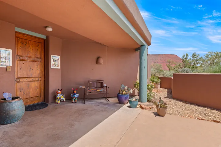 Covered porch with a wood-panel entry door and a stucco exterior finish