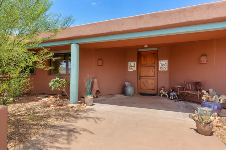 Covered entryway featuring a wood-paneled door, recessed lighting, and a stucco exterior