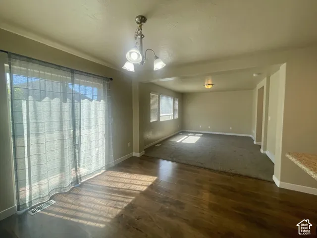 Wood-finish flooring, sliding glass door, recessed lighting, multiple windows, and carpeted area