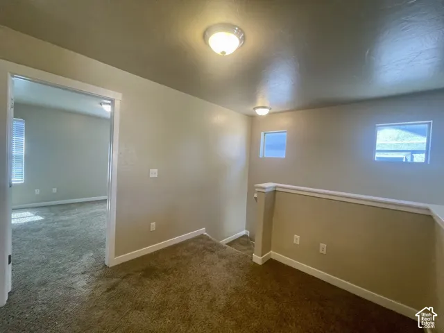Carpeted floor, neutral wall tones, two flush-mount ceiling lights, and two square windows