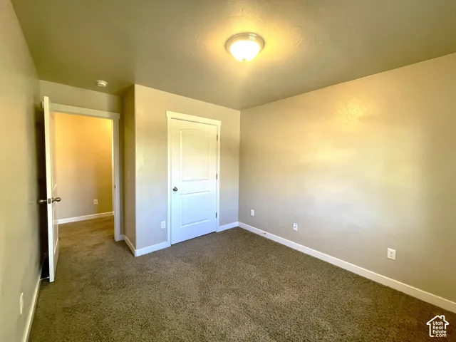 Neutral wall paint, textured ceiling, flush mount ceiling light, white interior doors, and carpet flooring
