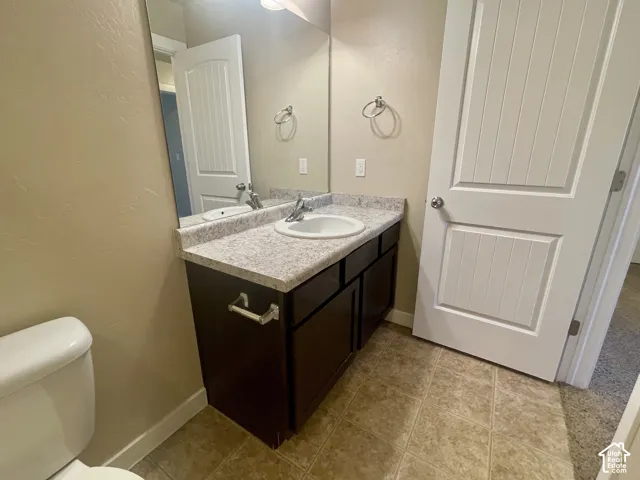 Vanity with a speckled countertop, integrated sink, and dual-handle faucet