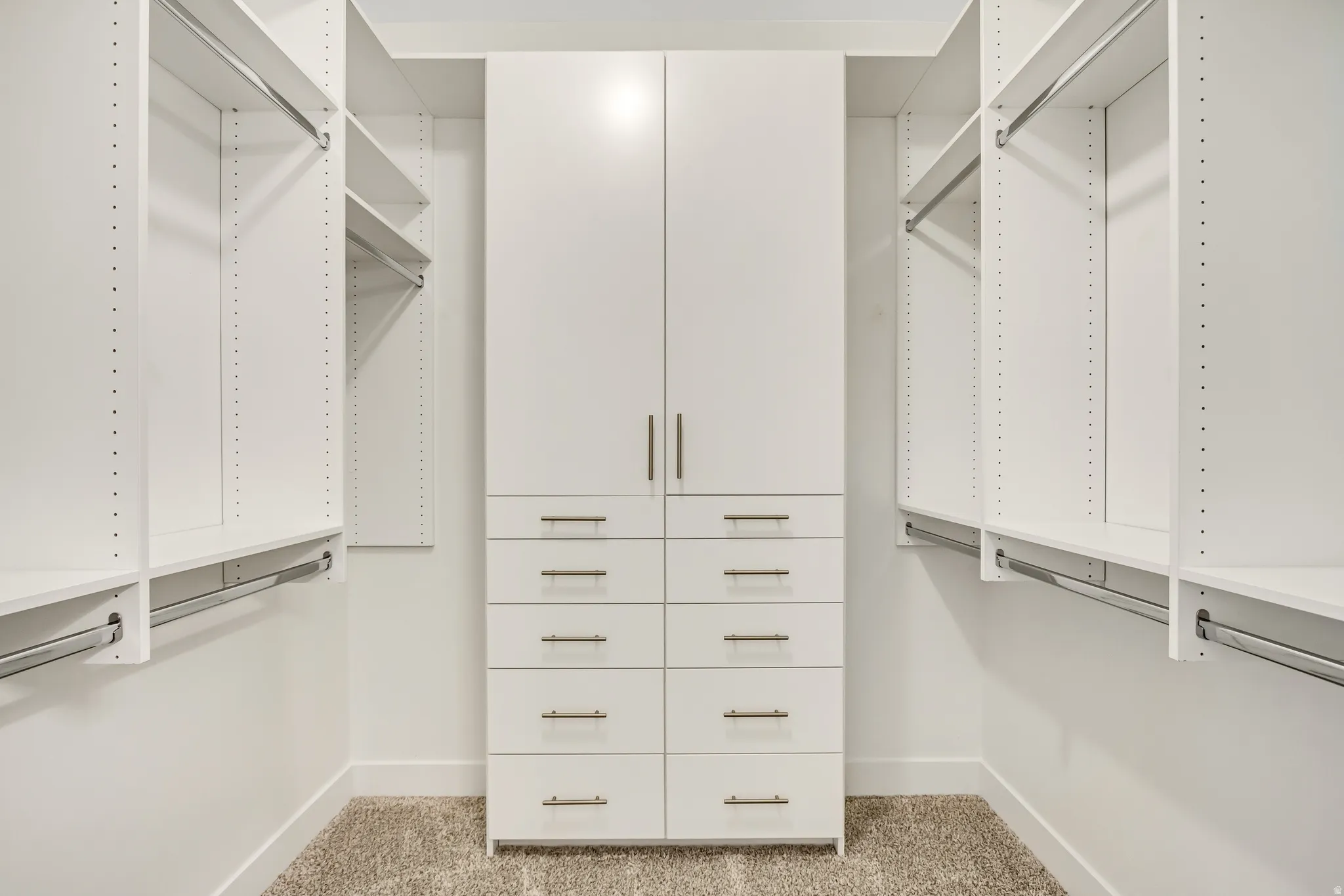 Custom closet system with integrated shelving, hanging rods, and central drawer storage