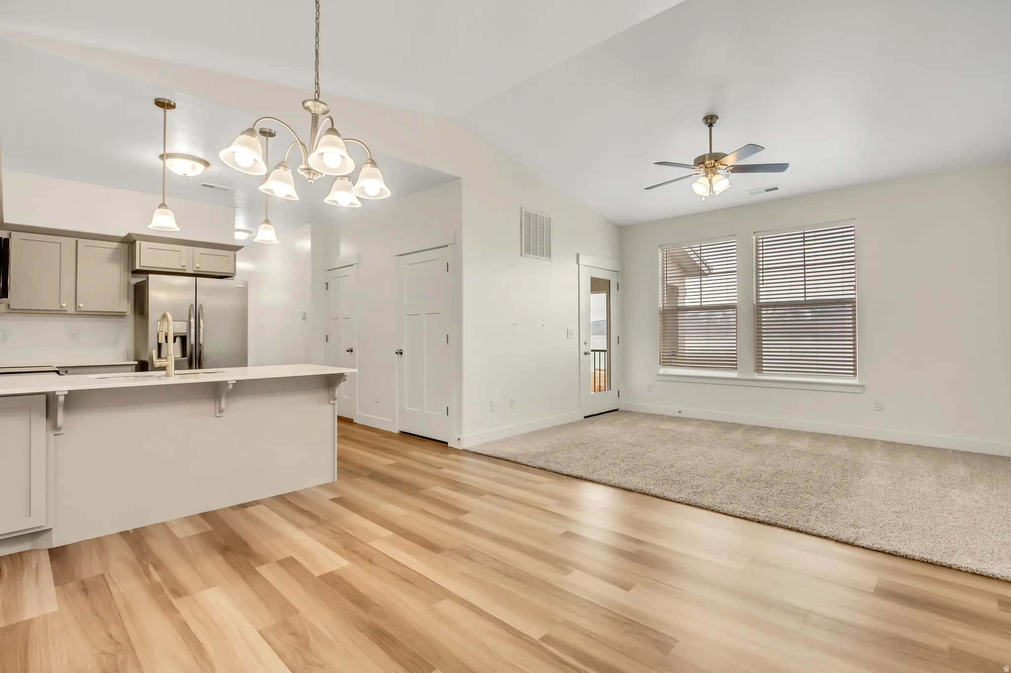 Open concept living area with vaulted ceilings and wood-finish flooring