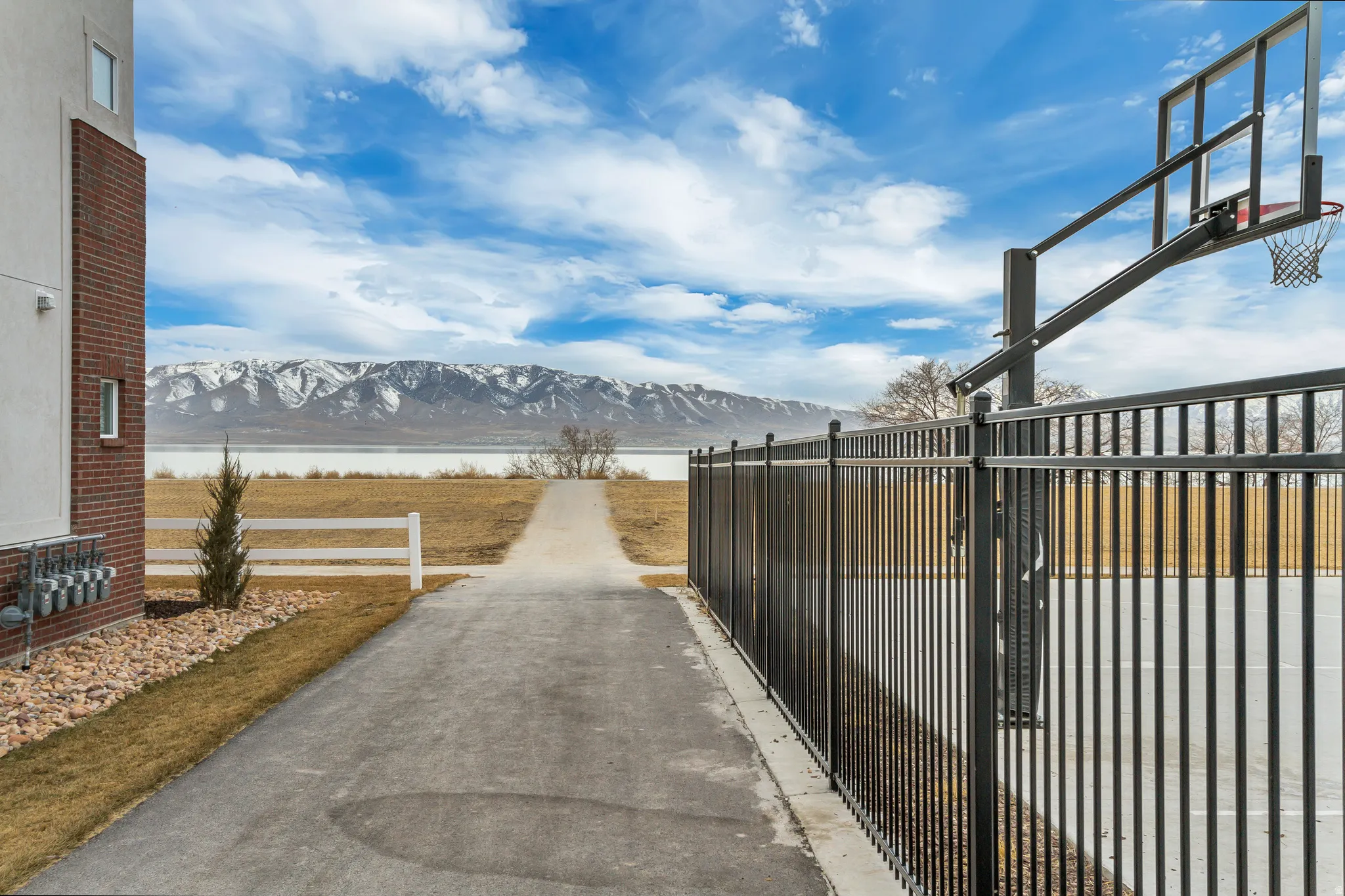 Paved walkway leading to a body of water with mountain backdrop