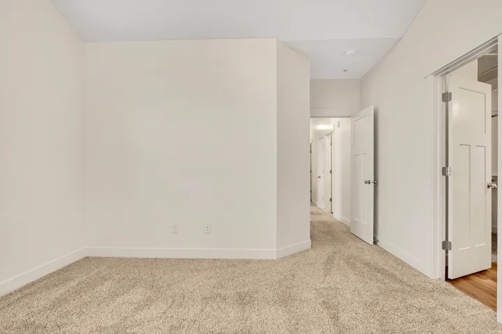 Soft neutral carpeting, white interior doors, and recessed lighting