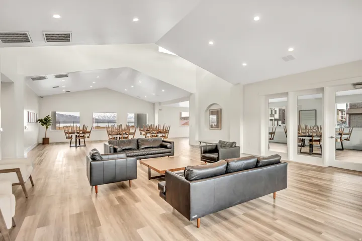Spacious communal area featuring vaulted ceilings, recessed lighting, wood-finish flooring, and multiple window exposures