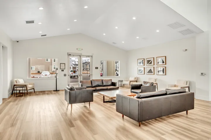 Vaulted ceiling with recessed lighting, wood-finish flooring, large windows, and a glass-paneled entry door