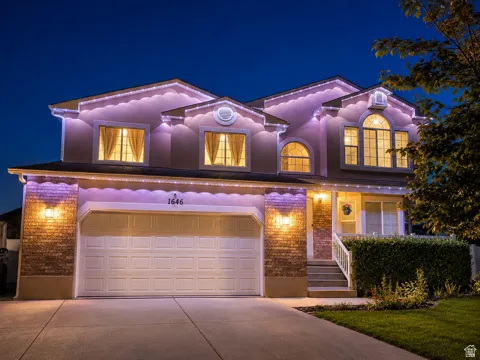 Stucco and brick exterior with arched windows, a two-car garage, and a concrete driveway