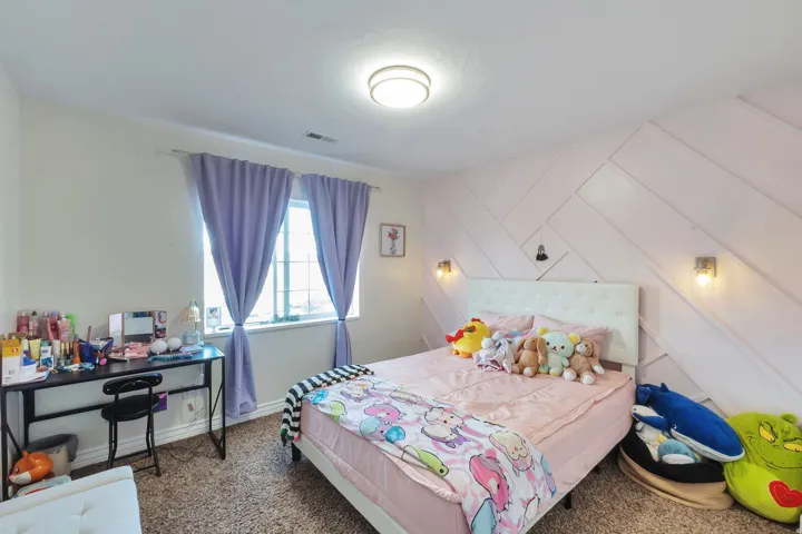 Carpeted room featuring a window with vertical blinds, a decorative accent wall, and ceiling-mounted lighting