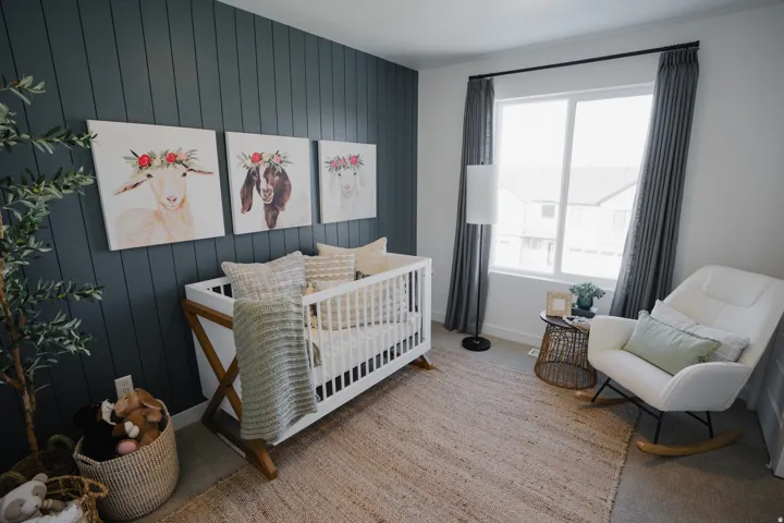Board and batten accent wall, large window with natural light, light-toned carpeting, and crown molding