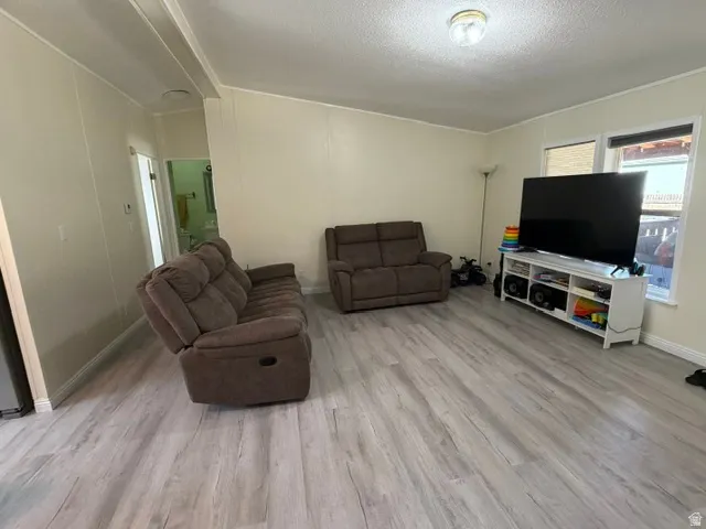 Light wood-finish flooring with white baseboards throughout