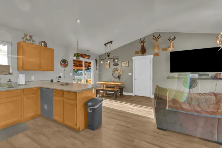 Kitchen featuring wood-finish cabinetry, light-toned countertops, and an integrated dishwasher
