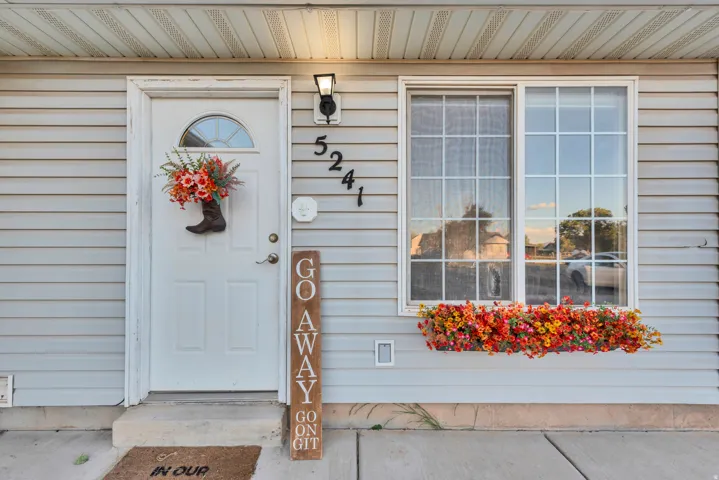 Front entry featuring a white paneled door with an arched window, a black outdoor light fixture, and horizontal siding