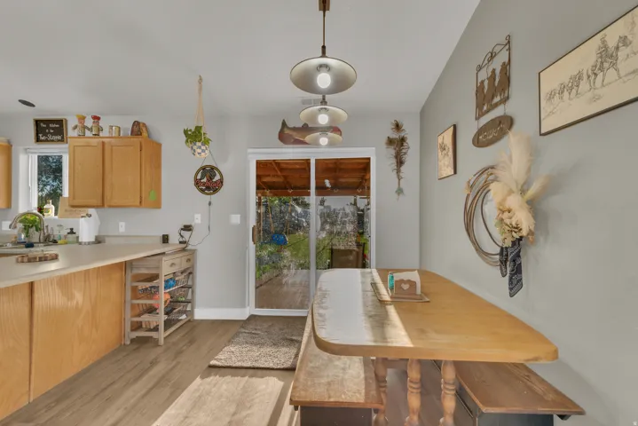 Kitchen featuring wood-finish flooring, light wood cabinetry, and a sliding glass door