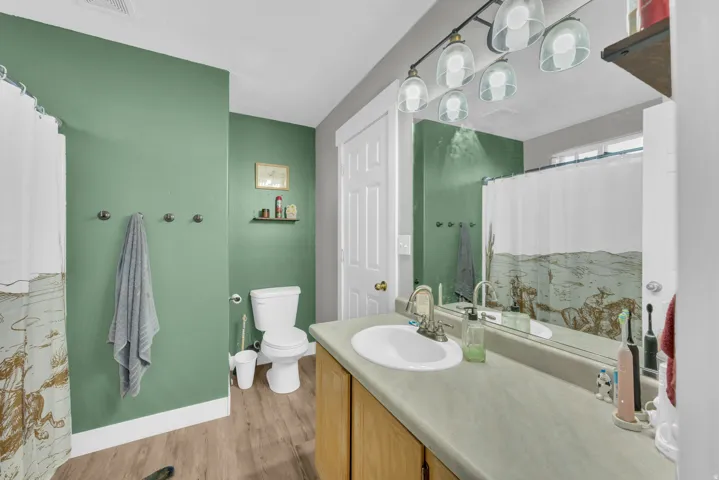 Vanity with an integrated sink, wood-finish cabinetry, and a full-width mirror