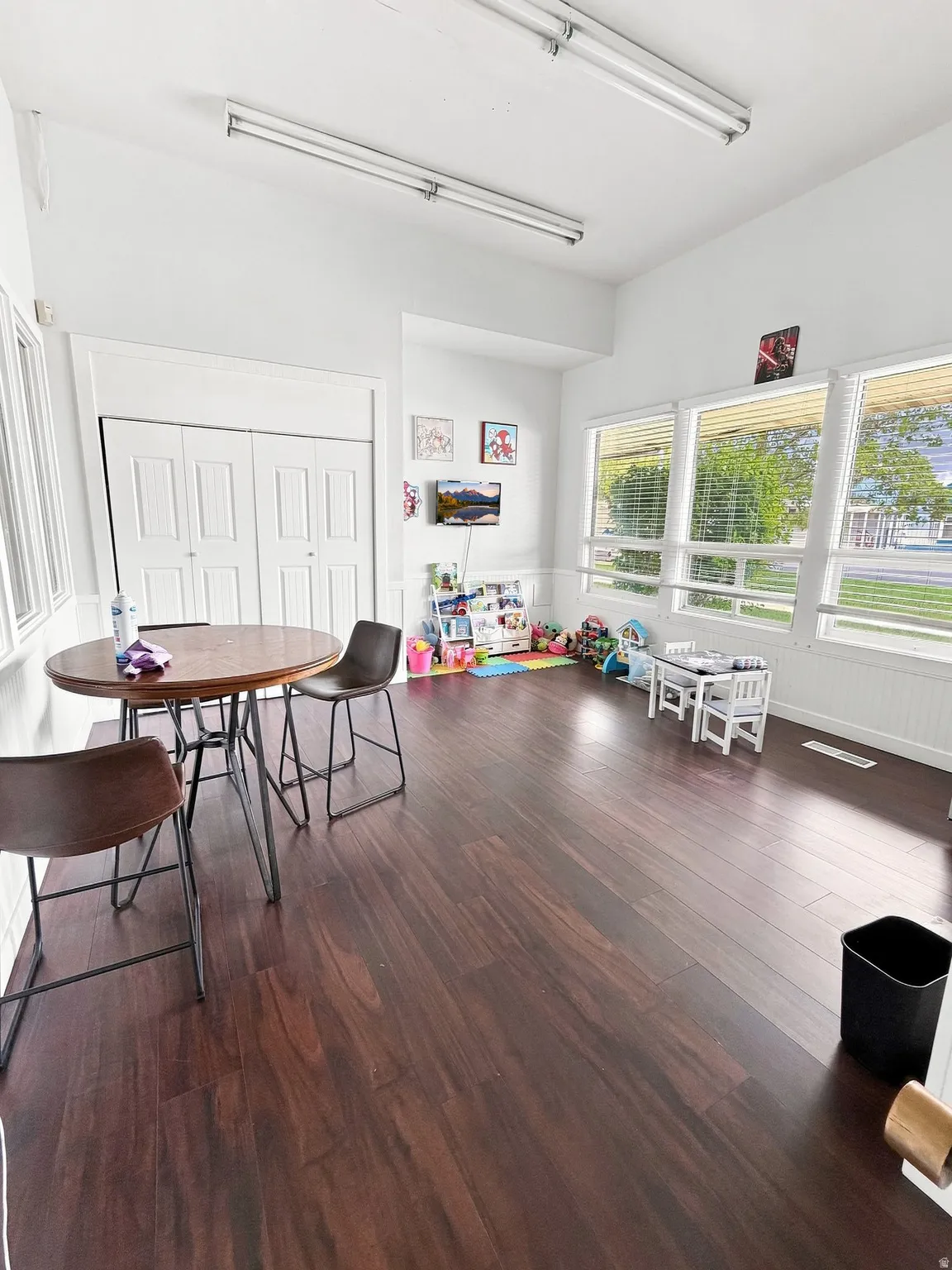 Wood-finish flooring throughout, white walls, and multiple windows providing natural light