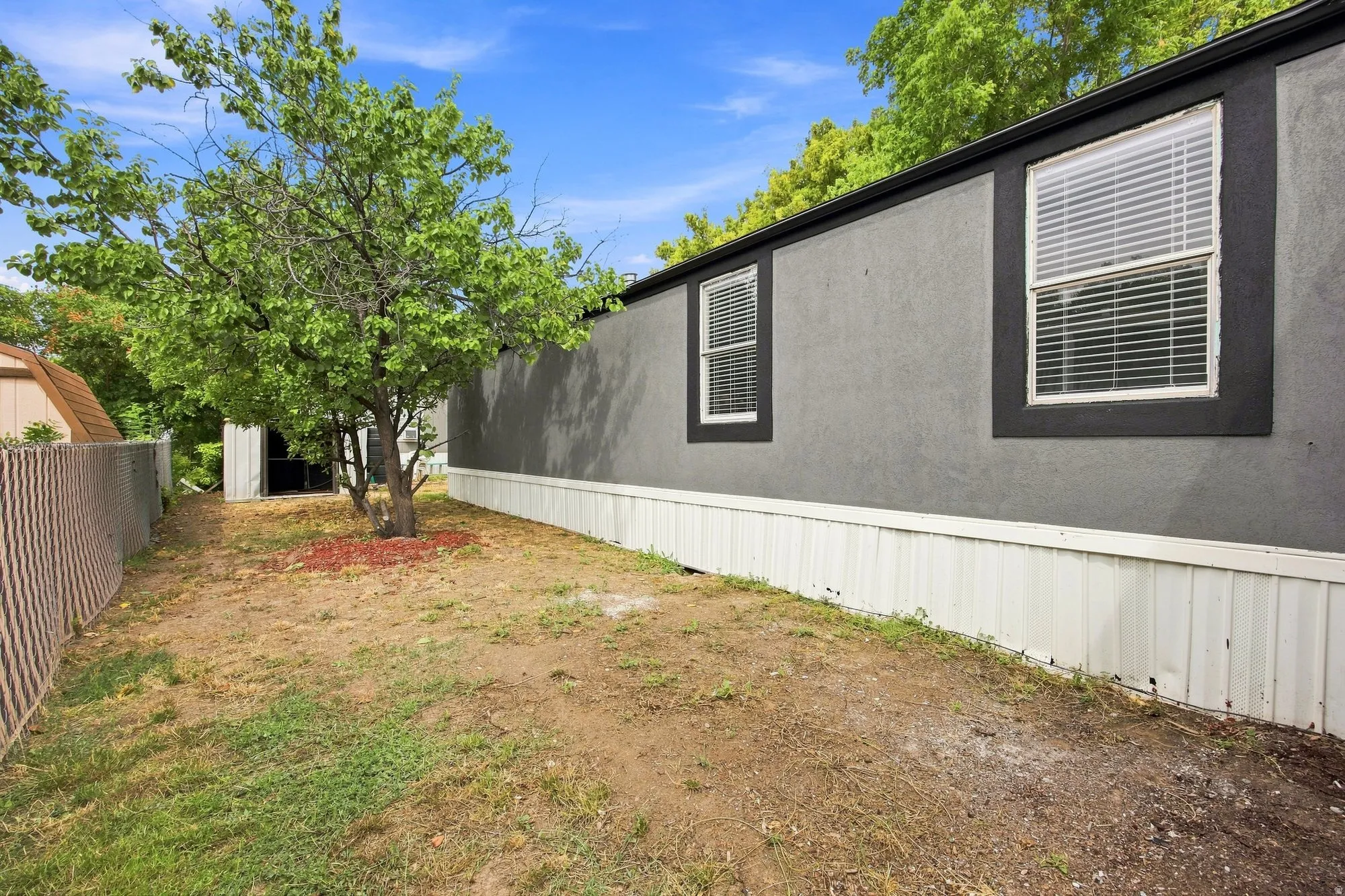 Exterior features include a stucco finish, dual pane windows with blinds, and white vertical paneling
