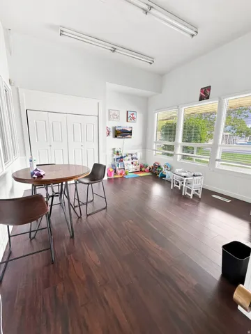 Wood-finish flooring throughout, white walls, and multiple windows providing natural light