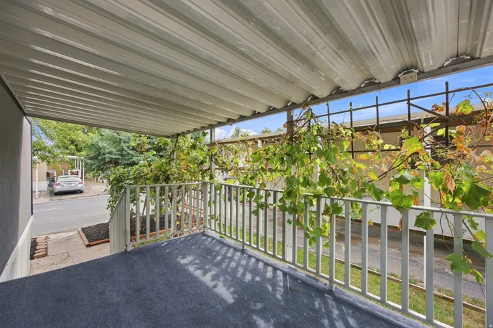 Covered porch with outdoor carpeting and white metal railings