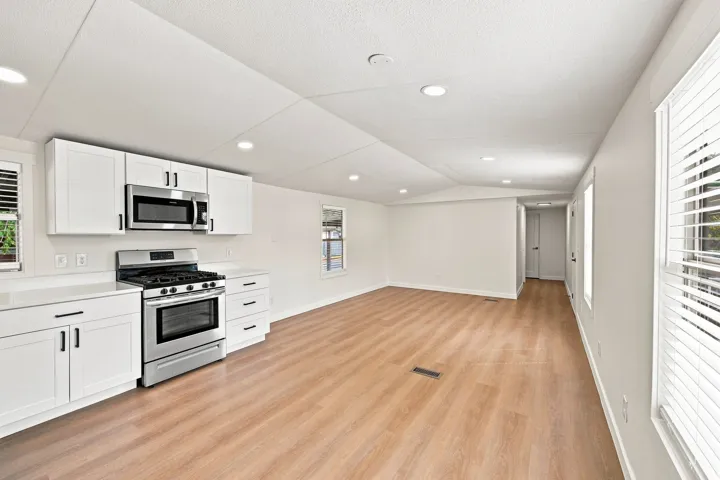 Open concept living area featuring wood-finish flooring, recessed lighting, and white walls