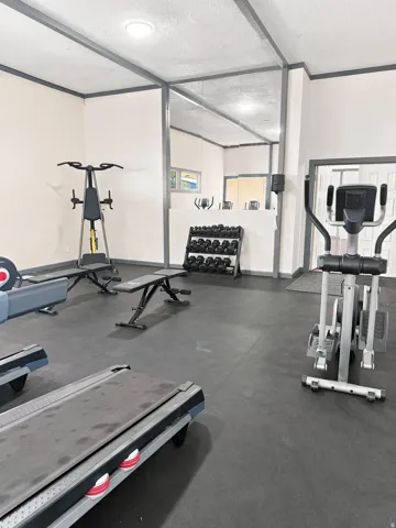 Fitness area featuring rubber flooring, recessed lighting, and mirrored wall panels