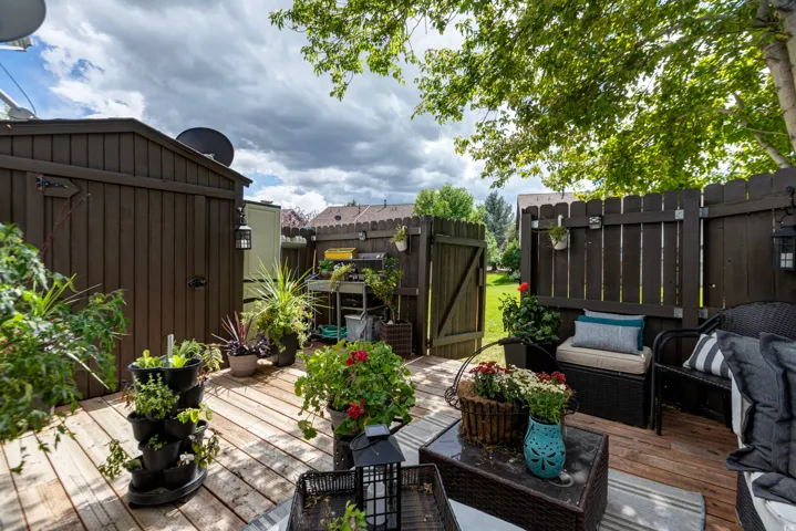Wood-finish deck with a privacy fence, wood-finish storage shed, and a gated yard access