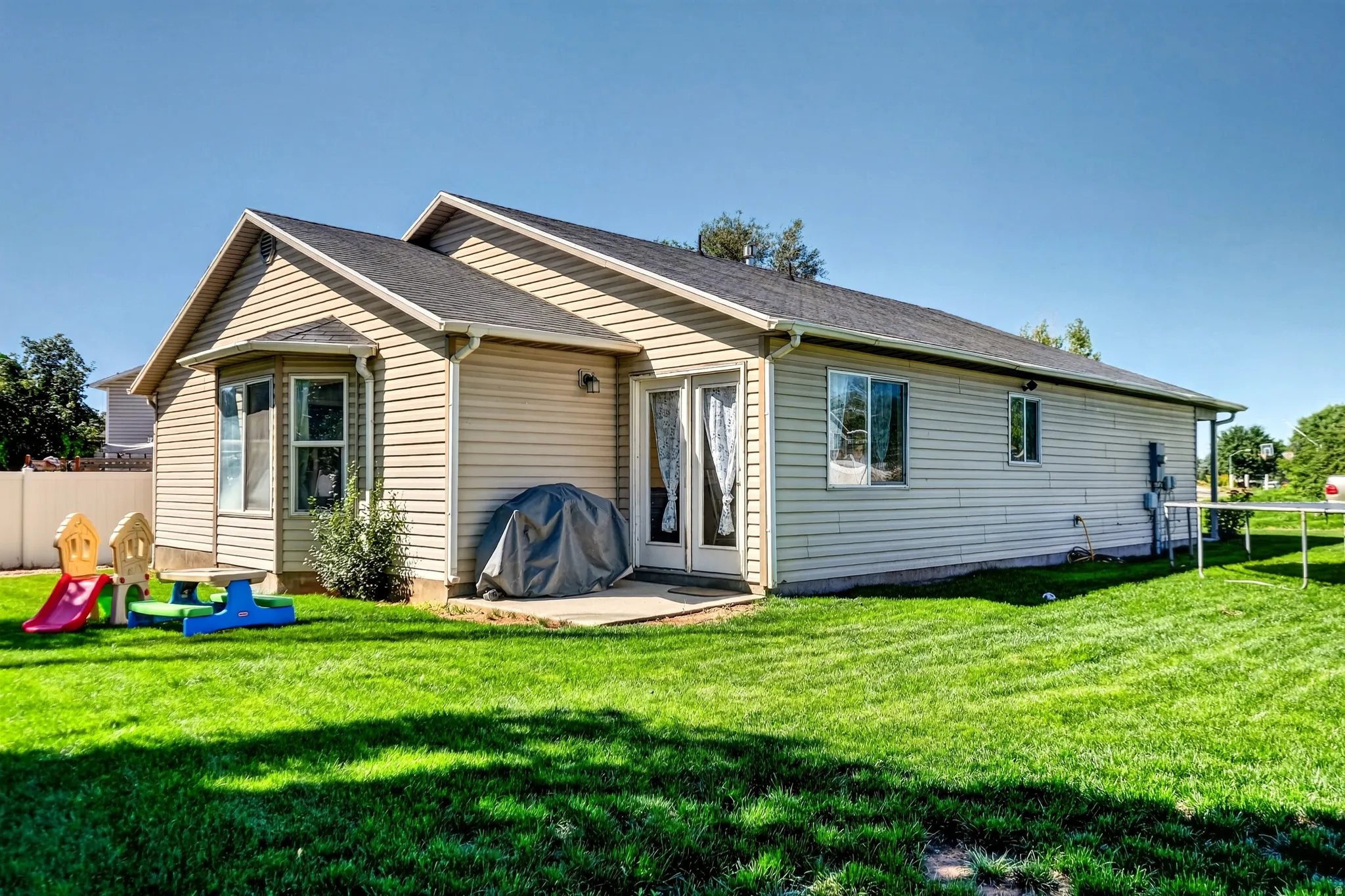Expansive green lawn with a concrete patio