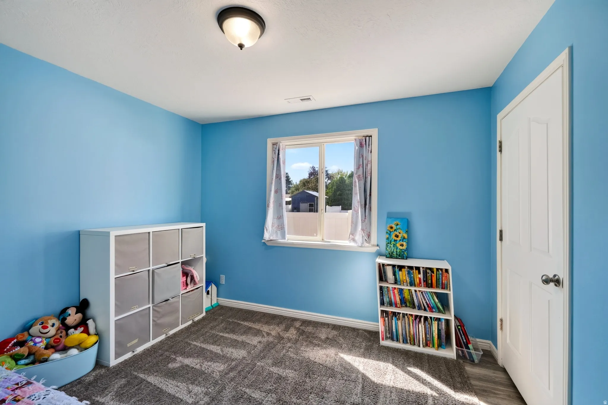 Neutral wall color with a contrasting white trim, featuring a window and a ceiling-mounted light fixture