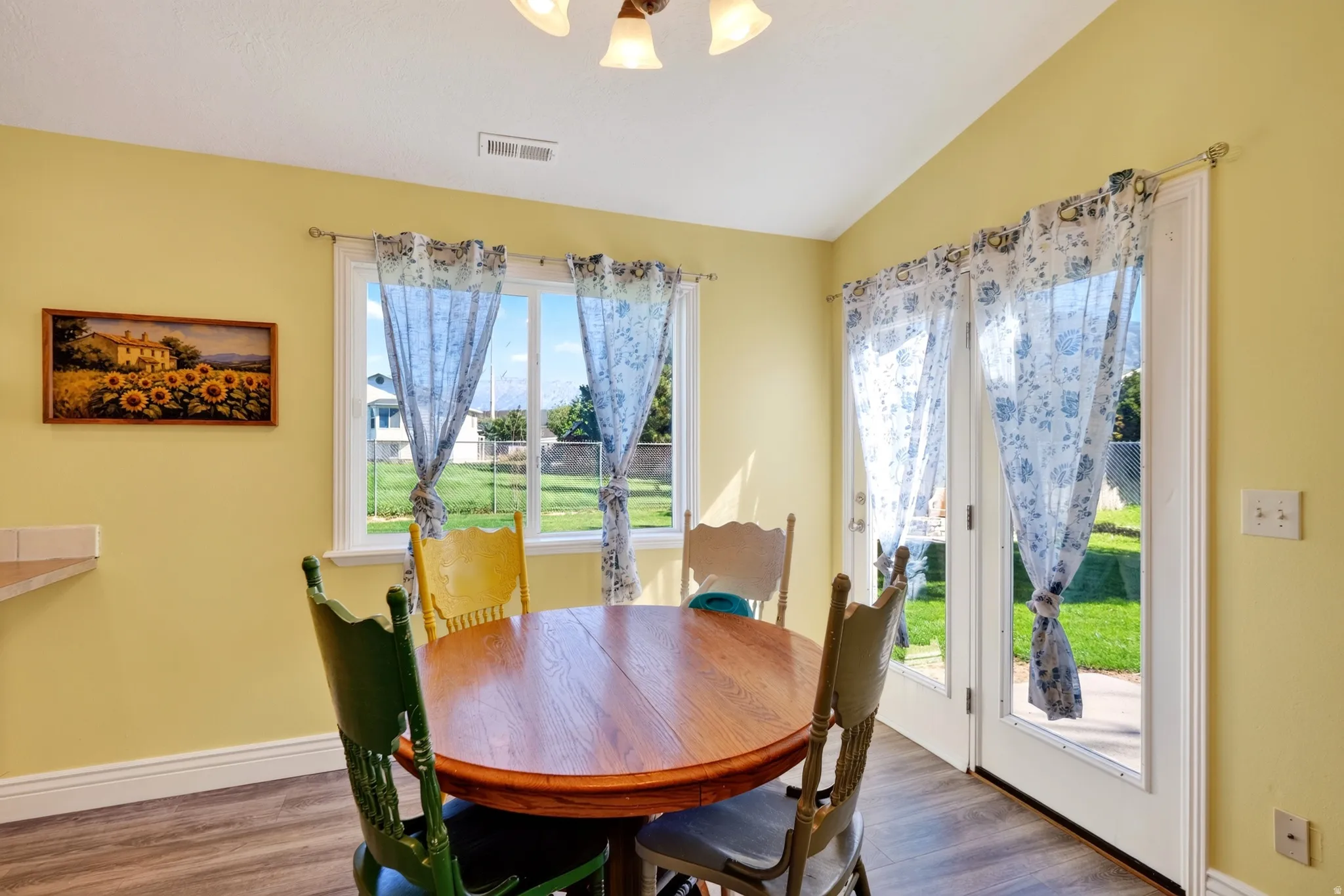 Wood-finish flooring, white baseboards, and a ceiling light fixture