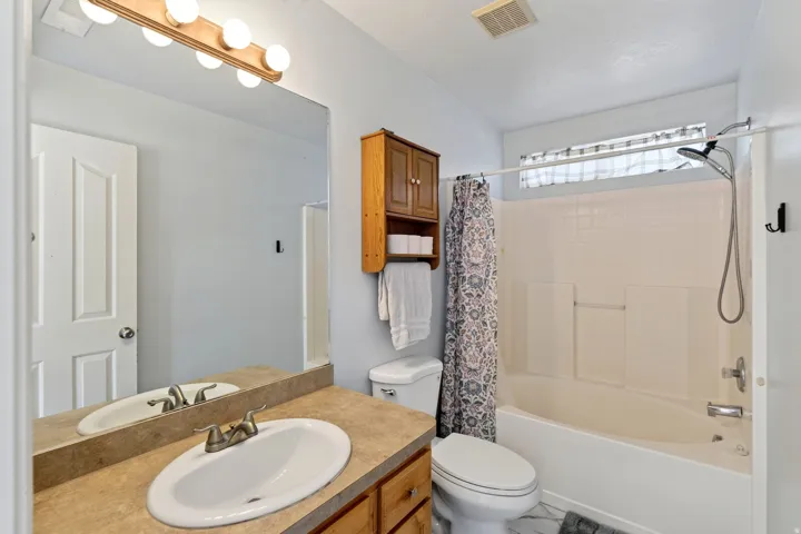 Single vanity with an oval sink, brushed nickel faucet, and a large wall-mounted mirror