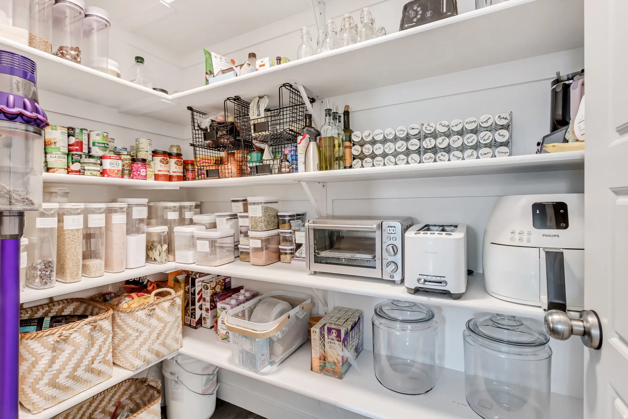 Customizable shelving offering extensive storage, white painted shiplap walls, and a white interior door with a brushed nickel knob