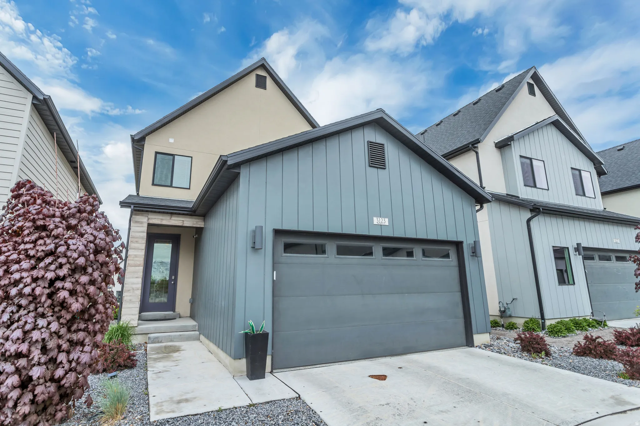 Contemporary exterior featuring light grey vertical siding and beige stucco accents