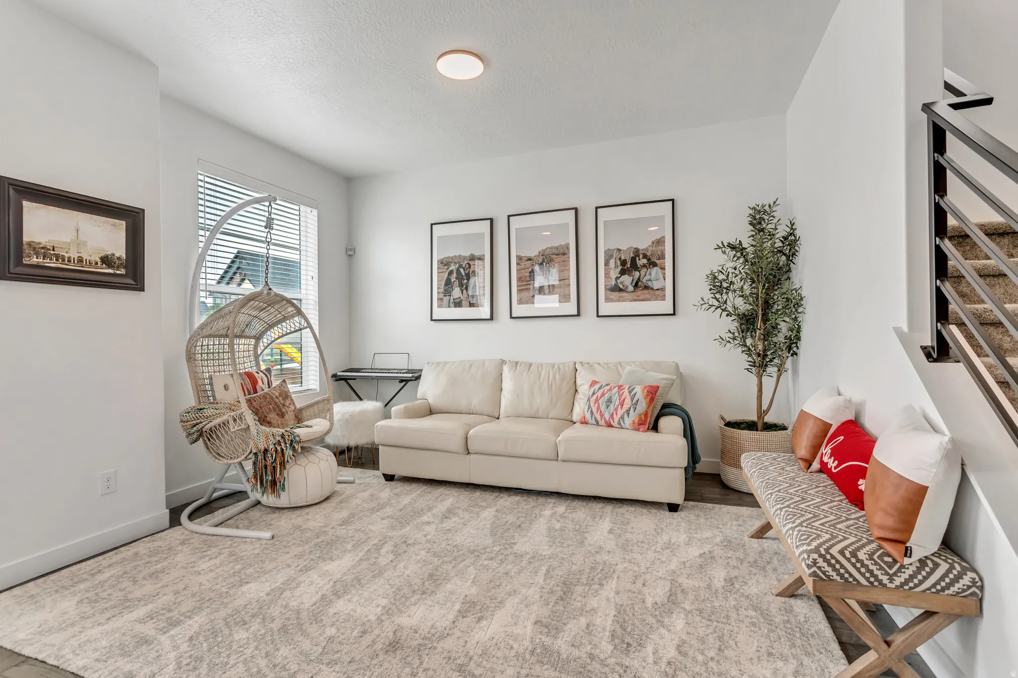 Bright room featuring a large window, recessed lighting, and a contemporary staircase with metal railings