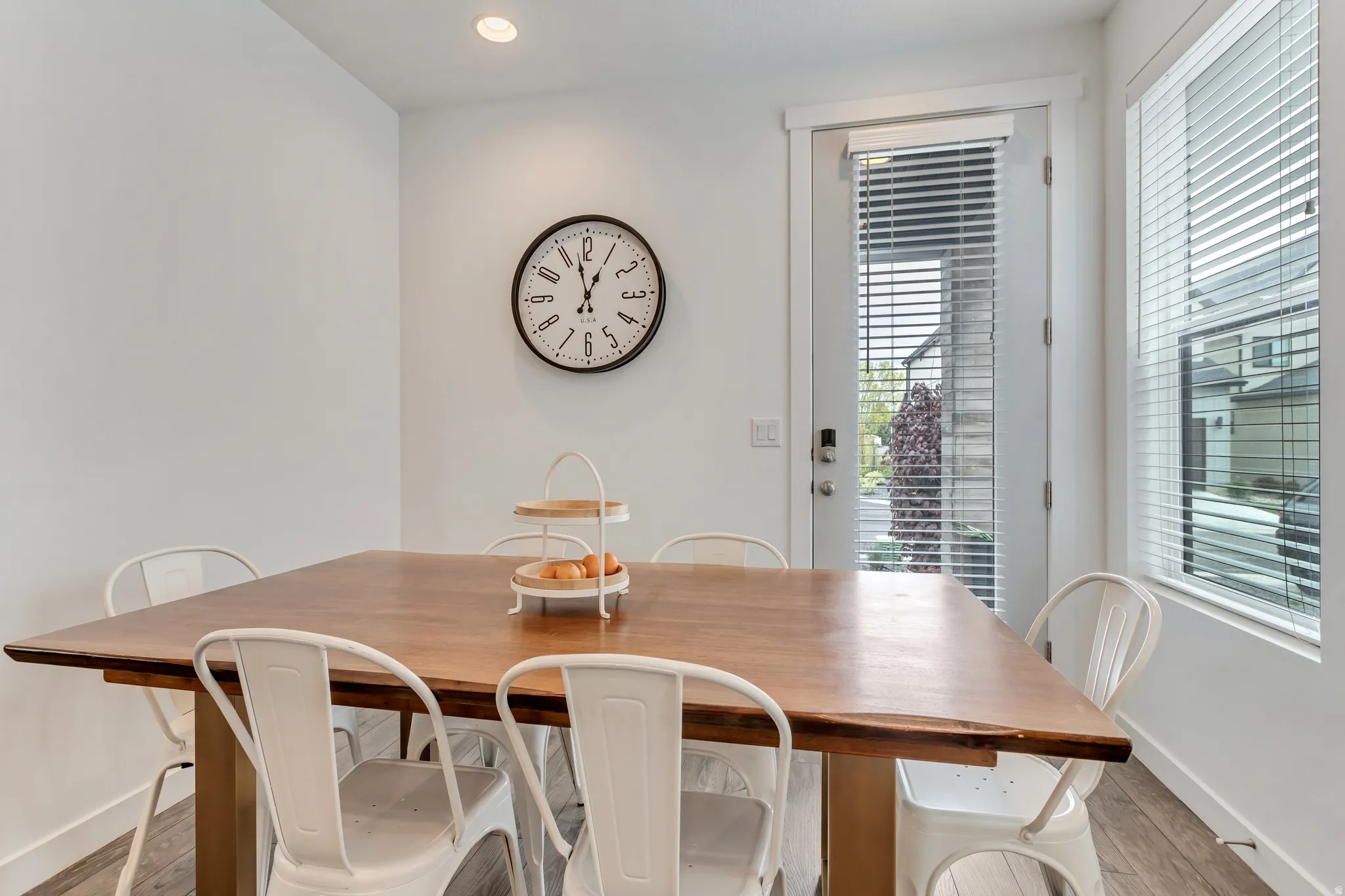 Recessed ceiling lighting, wood-finish flooring, white walls, white trim, and a glass-paneled door