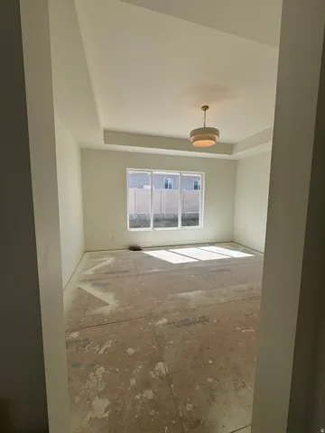 Tray ceiling with crown molding, contemporary drum pendant light, and triple window