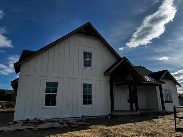 White board-and-batten siding with a dark gabled roof