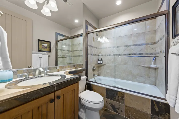 Wood-finish vanity with a stone countertop and integrated sink