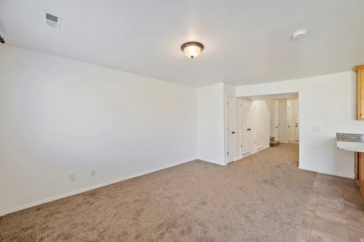 Light-toned wall finishes, neutral carpeting, and a built-in counter with a stone-finish surface
