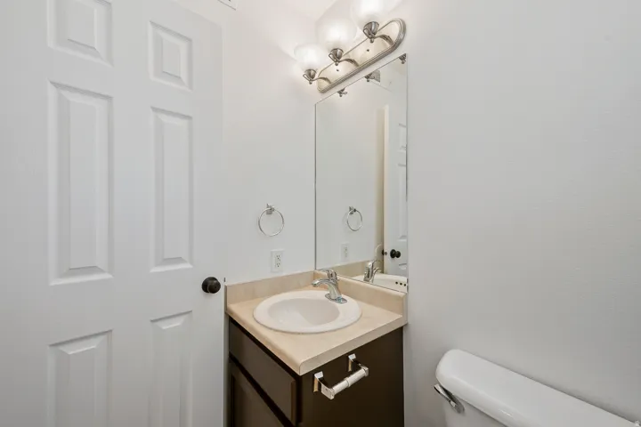 Vanity with an integrated sink, polished chrome faucet, and a wall-mounted mirror