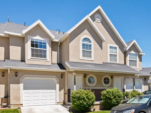 Stucco exterior with white trim accents and a gray shingle roof