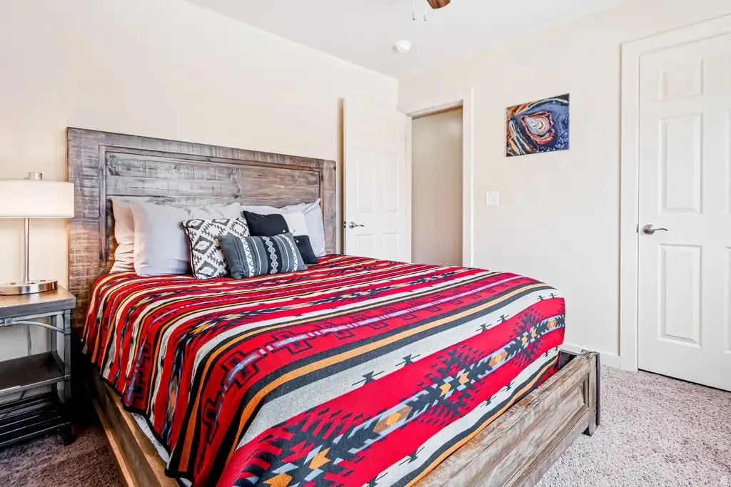 Neutral wall paint, textured carpet flooring, painted interior doors, and a ceiling fan