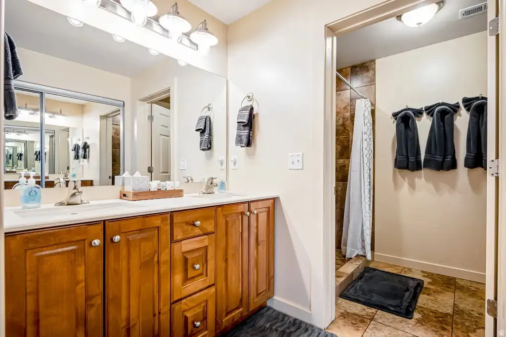 Dual vanity with wood-finish cabinetry and chrome fixtures