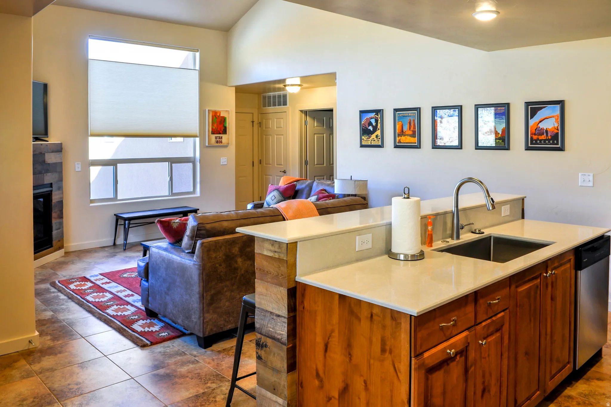 Open-concept kitchen featuring wood cabinetry, stainless steel appliances, and a built-in sink