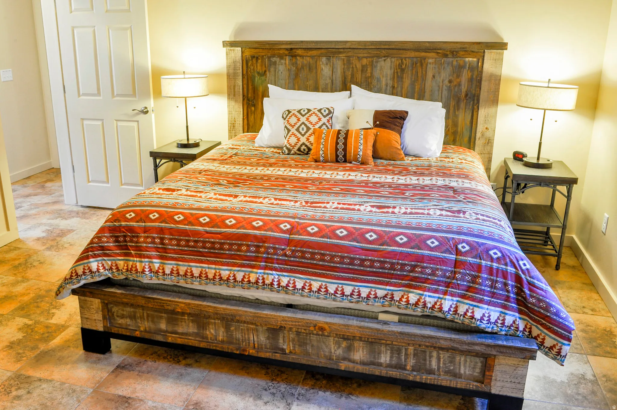 Warm-toned flooring and a built-in reclaimed wood bed frame