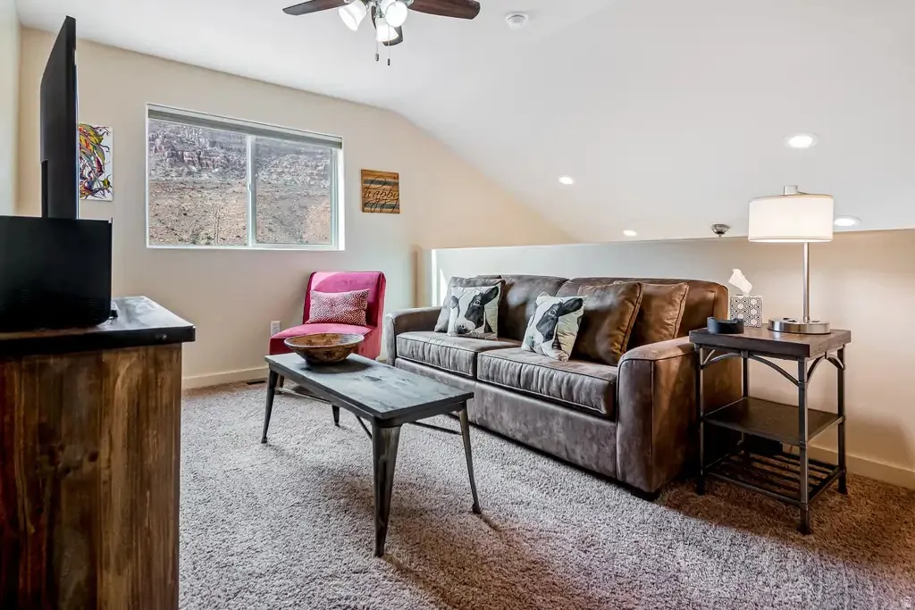 Sloped ceiling design, recessed lighting, and a ceiling fan